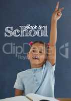 Student girl at table raising hand against blue blackboard with back to school text