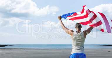 Man holding a USA flag in the beach