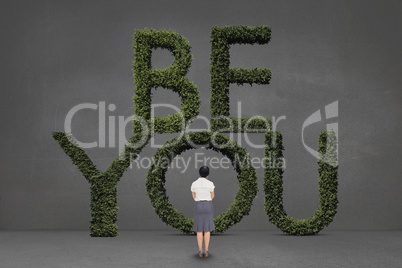 Business woman standing in front of a motivational text