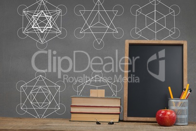 Books on the table against grey blackboard with education and school graphics