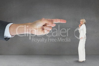 Hand pointing at business woman against grey background