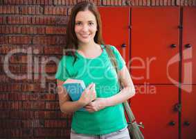 female student holding book in front of lockers