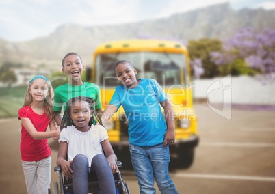 Disabled girl in wheelchair with friends in front of school bus