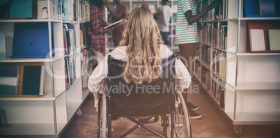 Disabled girl on wheelchair in library