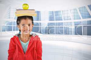 Composite image of smiling girl balancing books and apple on head