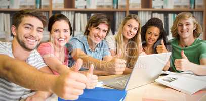 Composite image of college students gesturing thumbs up in library