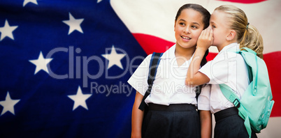 Composite image of girl whispering in friend ear