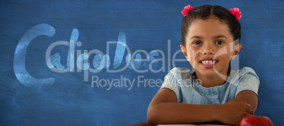 Composite image of smiling girl sitting at desk