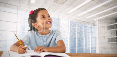 Composite image of girl looking up while sitting at desk