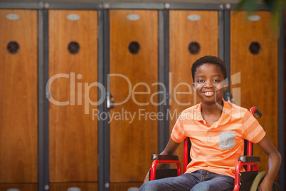 Composite image of portrait of boy sitting in wheelchair at library