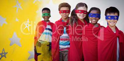 Composite image of smilnig children in superhero costumes