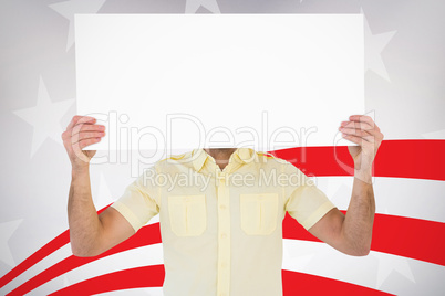Composite image of man holding card in front of his face