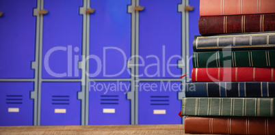 Composite image of stack of books on wooden table