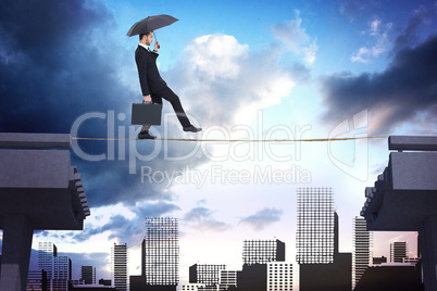 Composite image of businessman holding briefcase under umbrella