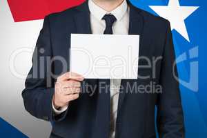 Composite image of businessman showing card to camera