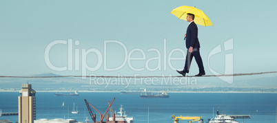 Composite image of businessman with yellow umbrella walking on white background