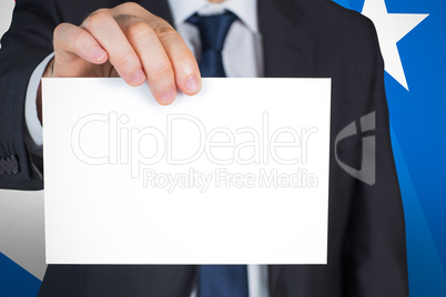 Composite image of mature businessman showing card