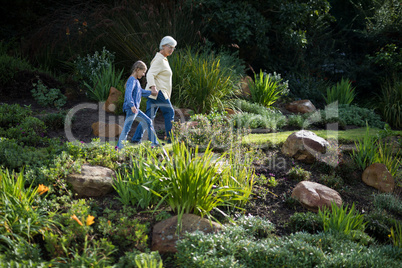 Grandmother and granddaughter walking in the garden