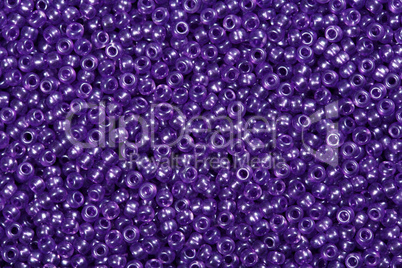 Many purple glass cane beads, background.