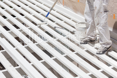 Professional Painter Rolling White Paint Onto The Top of A Home