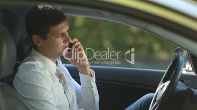 Busy business executive talking on phone in car
