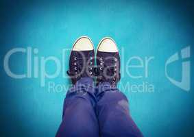 Black shoes on feet with blue background