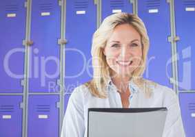 Mature female student holding file in front of lockers