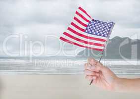 Person holding a USA flag in the beach