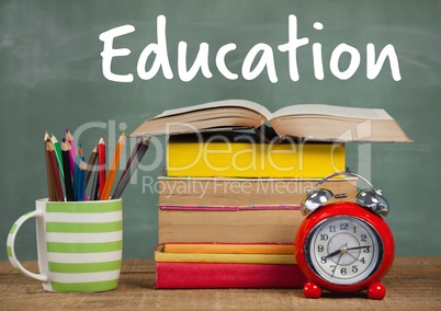 Books on Desk foreground with blackboard Education text