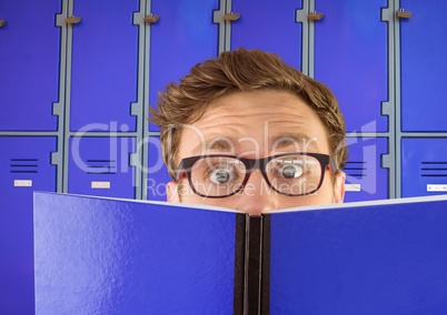 male student holding book in front of lockers