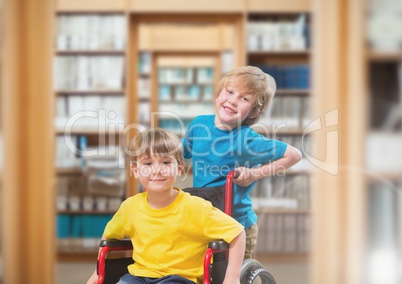 Disabled boy in wheelchair with friend in school library