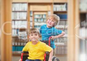 Disabled boy in wheelchair with friend in school library