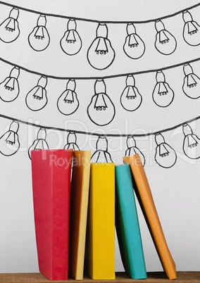 Books on the table against white blackboard with bulb graphics