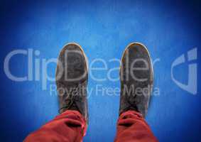 Grey shoes on feet with blue background