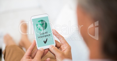 Man holding a phone with travel insurance concept on screen