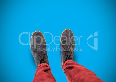 grey shoes on feet with blue background