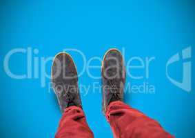 grey shoes on feet with blue background