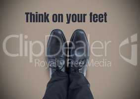 Think on your feet text and Black shoes on feet with brown background