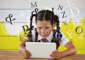 Many letters around Girl on tablet in front yellow painted background