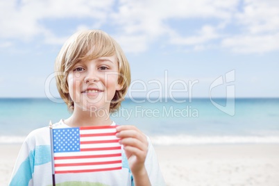 Happy boy holding a USA flag in the beach