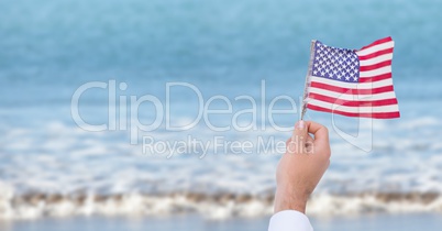 Person holding a USA flag in the beach