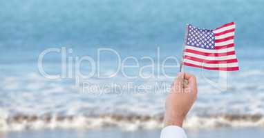 Person holding a USA flag in the beach