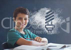 Student boy at table against blue blackboard with school and education graphic