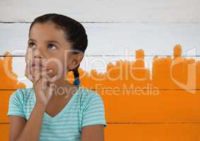 Girl thinking in front of orange painted background