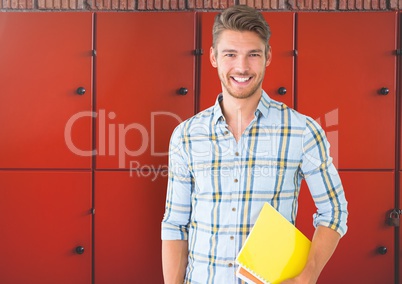 male student holding book in front of lockers