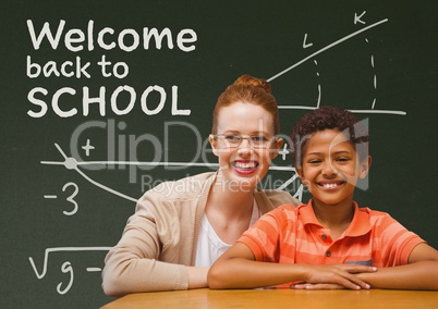 Student boy and teacher at table against green blackboard with welcome to school text