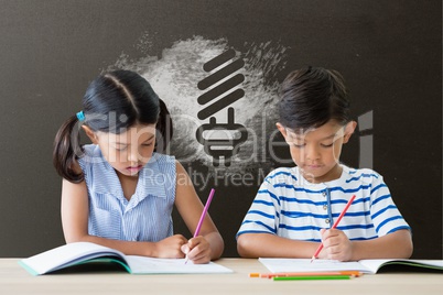 Students at table writing against grey blackboard with school and education graphic