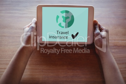 Person holding a tablet with travel insurance concept on screen