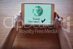 Person holding a tablet with travel insurance concept on screen