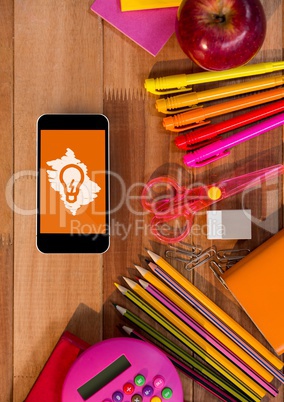 Phone on a school table with bulb icon on screen
